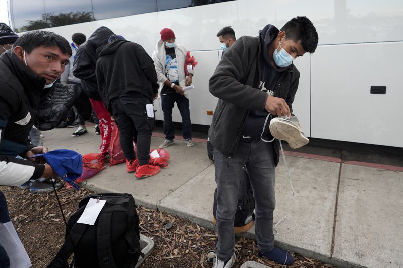 包括中國籍在內的數以百計的無證客突然被釋放出來，23日搭巴士抵達加州聖地牙哥市，下車後正在拿取行李，準備另謀出路。(美聯社)