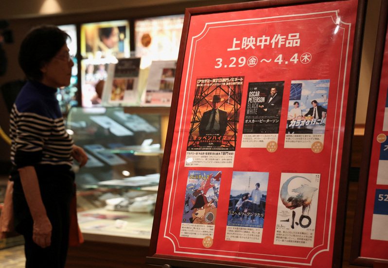 今年奥斯卡大赢家、去年热门强片「奥本海默」，在延宕数月后29日终于在日本上映；图为广岛一家电影院，一名女士正在观看最新的电影海报，其中包括「奥本海默」。路透(photo:UDN)
