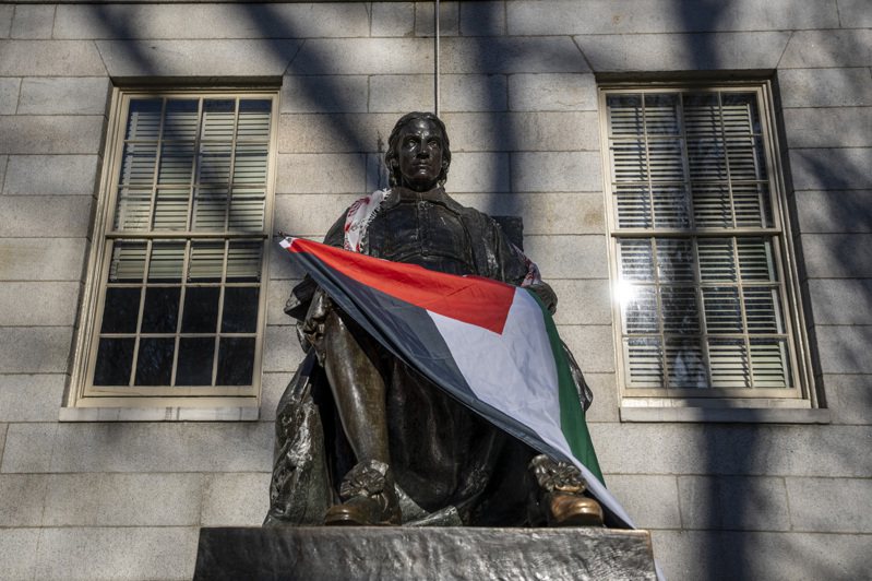 哈佛大学创始人约翰、哈佛的雕像被反以反犹示威学生披上巴勒斯坦旗帜。(美联社)