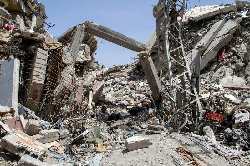 土耳其全面停止與以色列貿易，要求讓人道援助進加薩；圖為加薩日前可見巴勒斯坦民眾，坐在一處遭以色列炸毀的建築廢墟中。（路透）