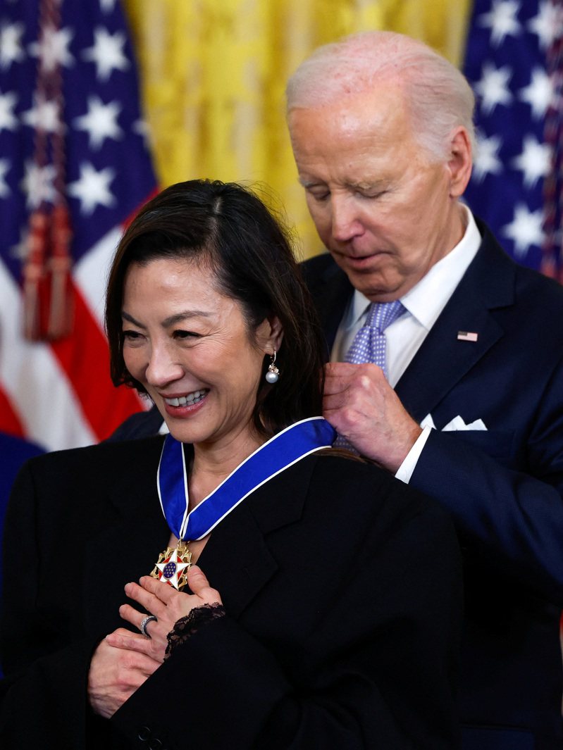 奧斯卡首位亞裔影后楊紫瓊(左)，在白宮舉行的頒獎典禮上，獲拜登總統(右)頒發總統自由獎章。路透社