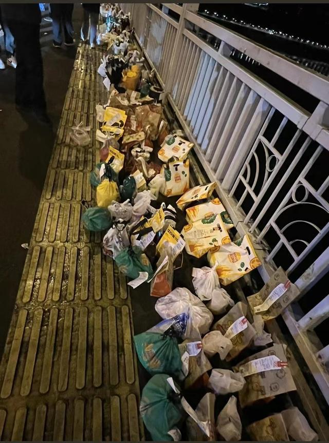 重慶長江大橋上祭奠「胖貓」的外賣成堆，被指浪費且影響交通。(取材自微博)