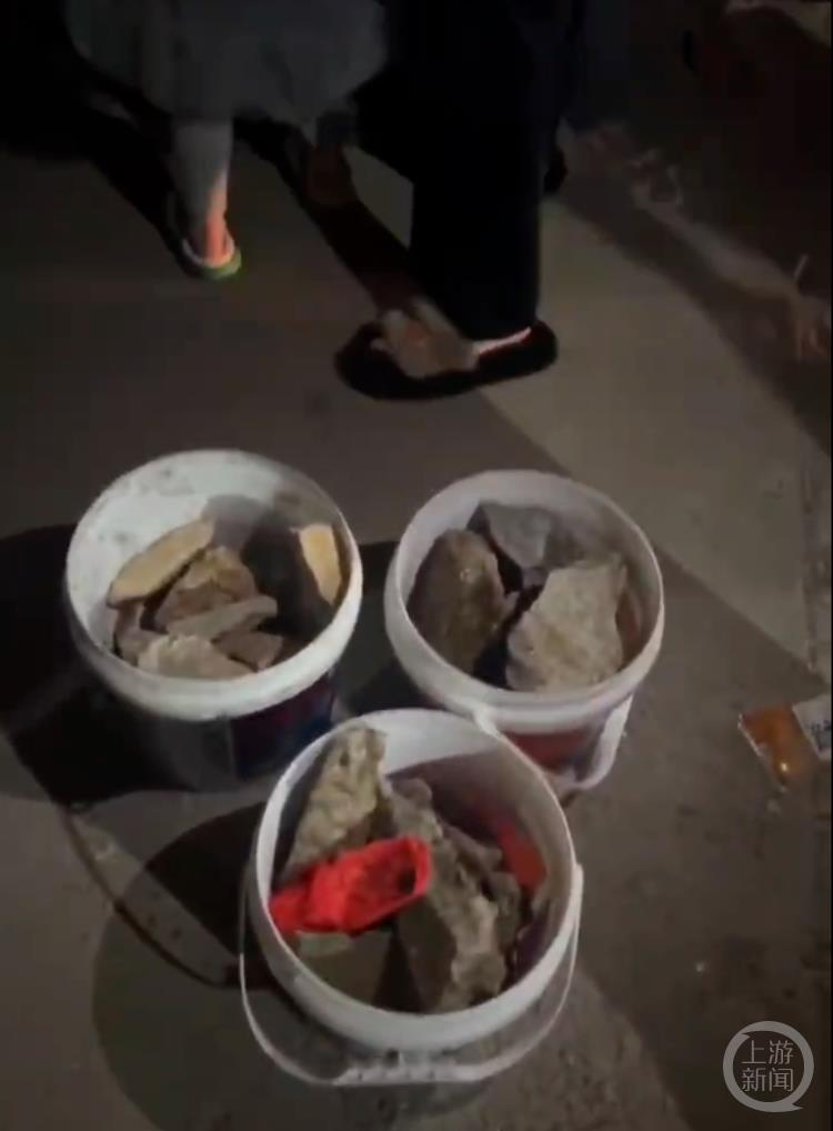 部分村民用塑料桶装著石头进行售卖。（取材自上游新闻）