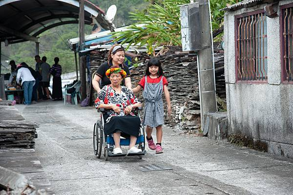 在圓夢專車和人力推送輪椅交替下, 歐阿嬤才得抵達舊家。 圖／王致尹攝影