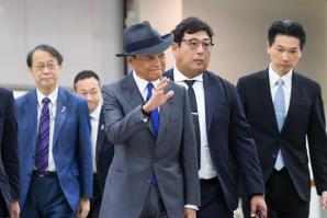 日本前首相暨自民黨副總裁麻生太郎（中）今天率團來台訪問，入境松山機場時遇到許多日本遊客在入境大廳等候，他也揮手向他們打招呼。記者余承翰／攝影