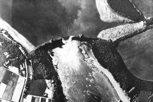 1943年5月17日，英國偵察機拍下的照片，顯示蒙恩水庫大壩中央已經崩塌，造成下游洪水。圖／皇家空軍檔案
