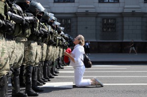 白俄羅斯首都明斯克一名反政府示威者跪在鎮暴警察防線前，攝於8月30日。美聯社