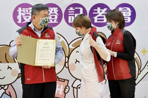 台北市柯文哲（左）為健康關懷天使們授證，副市長黄珊珊為關懷天使披上背心，避免造成男女分際問題。記者林伯東／攝影