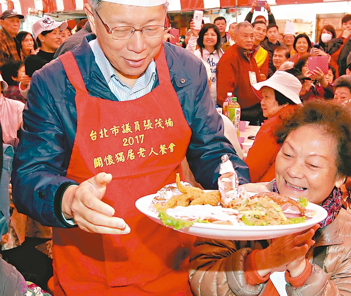 台北市長柯文哲出席獨居老人尾牙圍爐，戴高帽、穿圍裙扮廚師，並親自為老人家上菜。