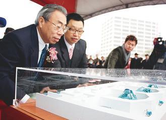台塑集團總裁王文淵（左）仔細看林口長庚醫院質子放射治療中心的質子機模型。 記者曾增勳／攝影