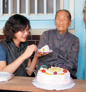 雲林縣水林鄉105歲人瑞王吳笑過生日，鄉長陳怡帆親自服侍老奶奶吃蛋糕。