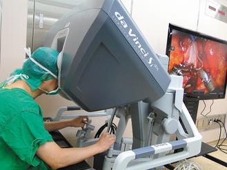 台大醫院完成亞洲第一例機器手臂腎臟移植手術，操刀的醫師蔡孟昆在另一處操控機器手臂，進行精細的顯微手術。 台大醫院/提供。
