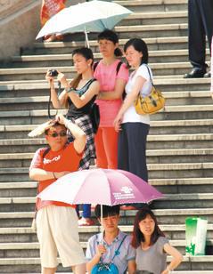 台北這幾天熱翻了，台北市中正紀念堂的遊客紛紛拿出陽傘防曬。 記者陳柏亨／攝影