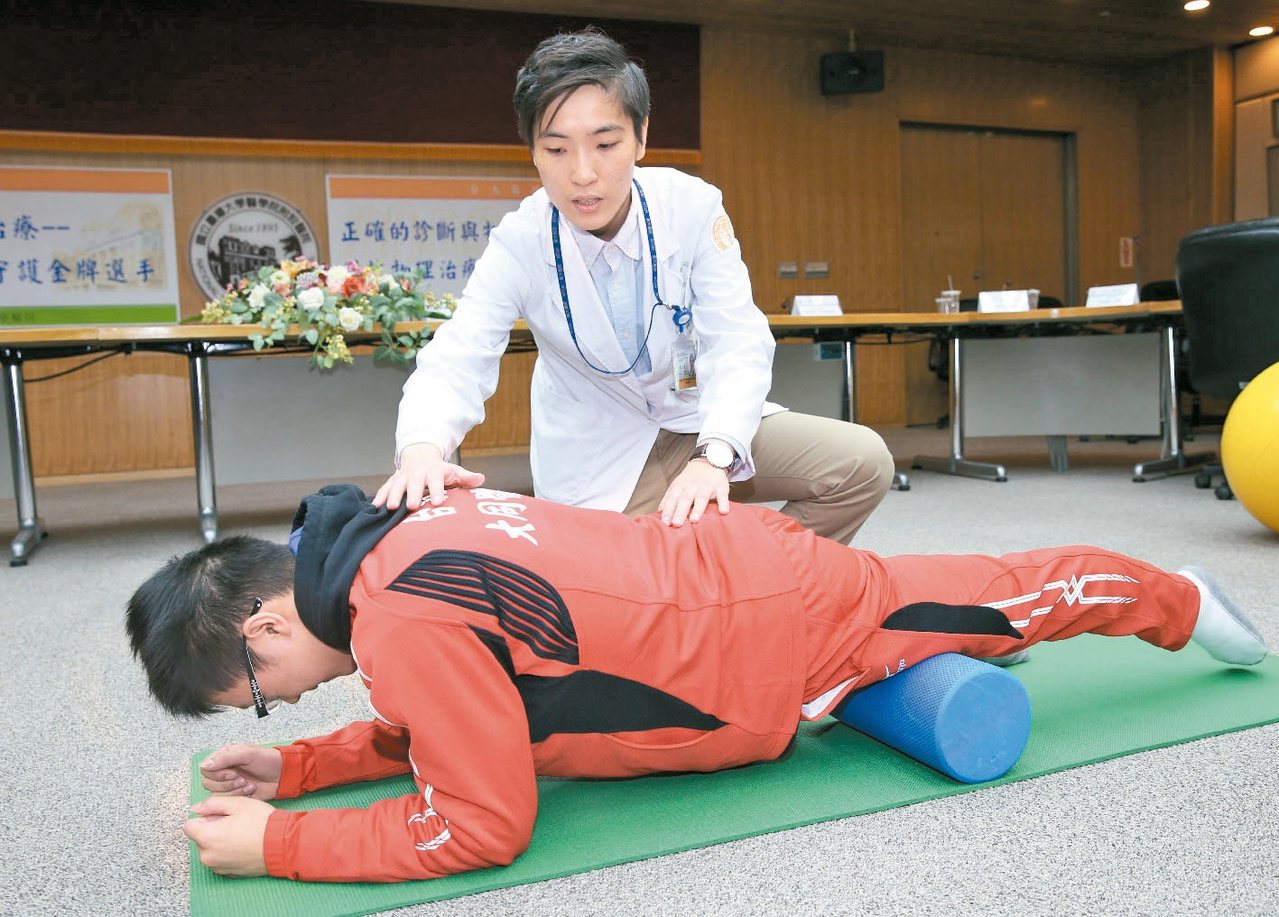 體操選手林冠儀(左)去年在國際少年運動會，拿到四面金牌，台大物理治療師楊宛青昨指導他下肢肌群放鬆。