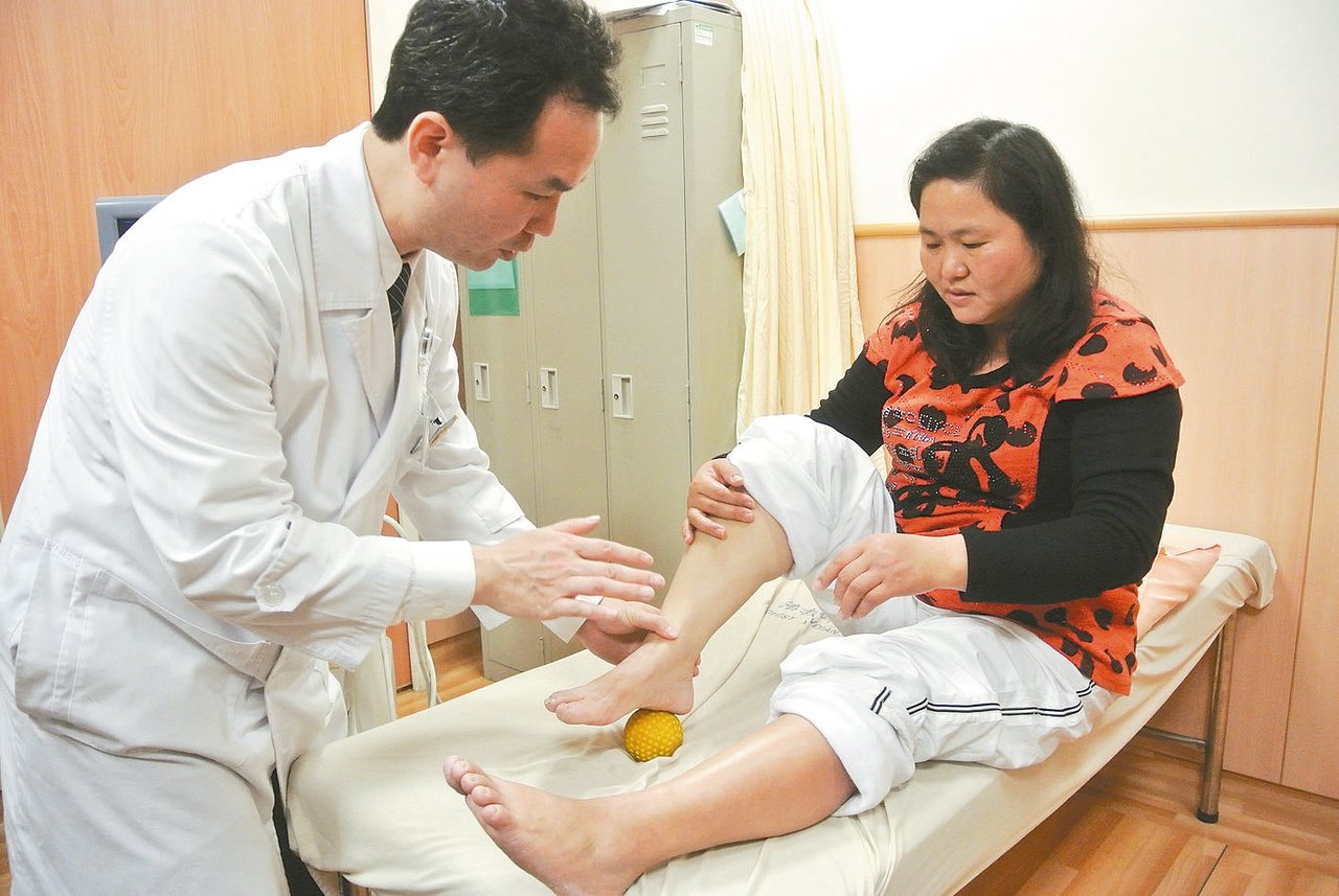 醫師蔡森蔚（左）教導患者，利用棒球、網球在腳底滾動，是足底筋膜炎的復健運動。