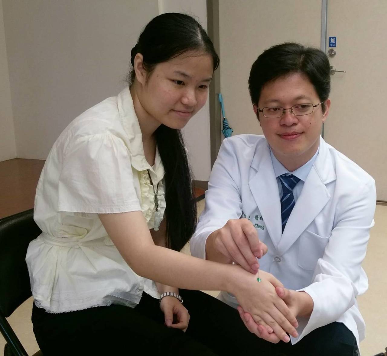 中國醫藥大學附設醫院中醫部醫師黃明正示範針灸穴位(靈骨穴)，可減緩疼痛。圖／中國醫藥大學附設醫院提供