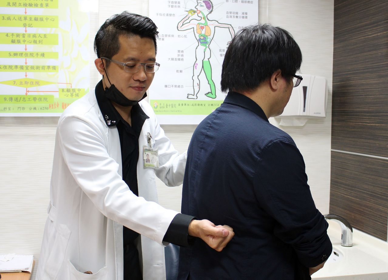 醫師孫宏舜（左）說明，王姓教授腰部疼痛位置（此為示意圖，非當事人）。圖／衛福部台中醫院提供