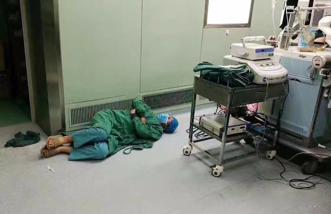醫生做24小时手術後太累，睡地板上。圖取自新浪網