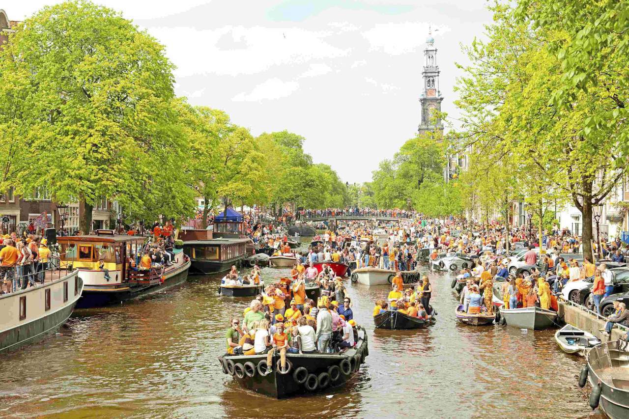 四月的荷蘭「國王節」，首都阿姆斯特丹充斥著橘色的熱鬧氛圍，處處可見群眾身穿橘色服...