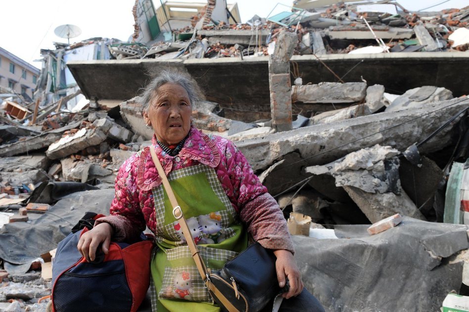 四川汶川地震給四川省多個縣市造成嚴重破壞，一位老人坐在映秀鎮一片廢墟前。圖／新華社