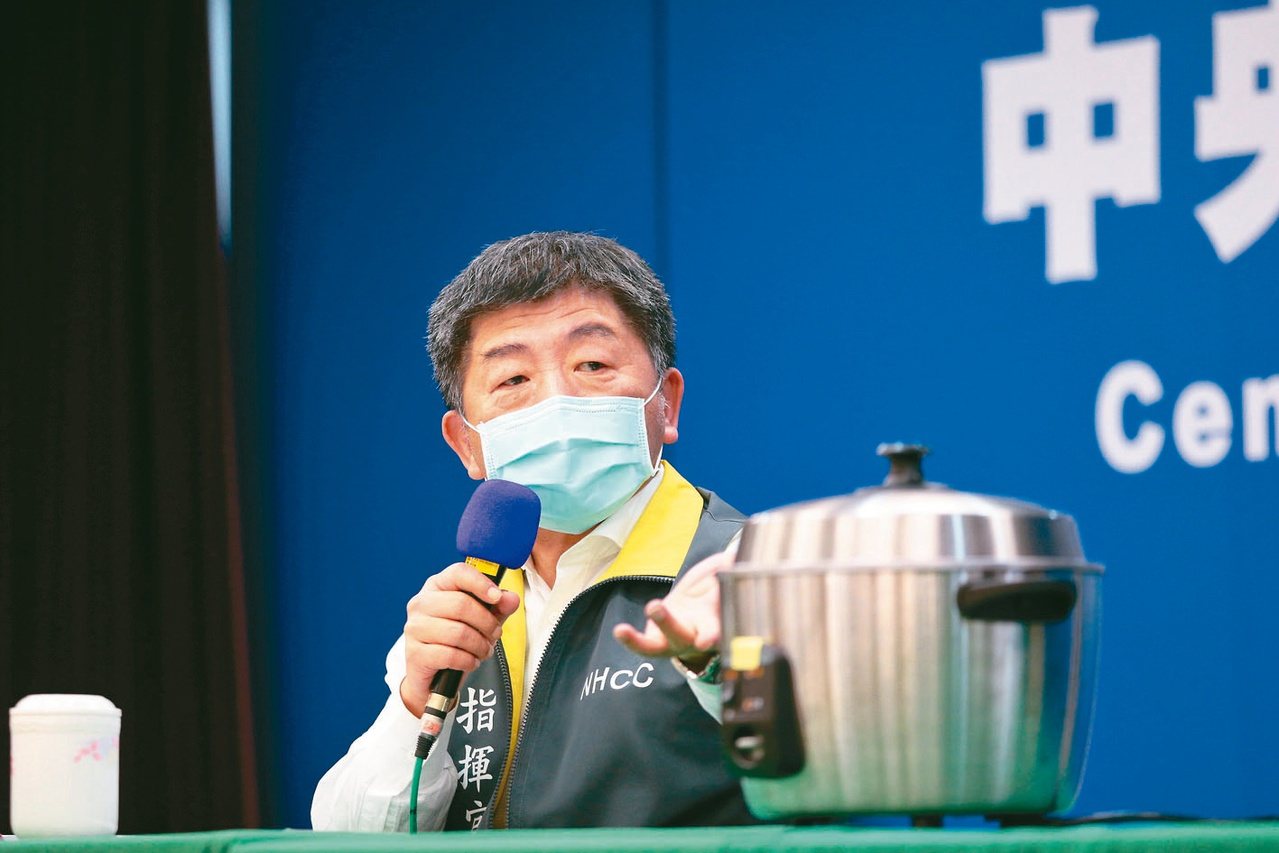 中央流行疫情指揮中心指揮官陳時中在記者會現場準備電鍋，教大家如何蒸烤口罩重複使用。