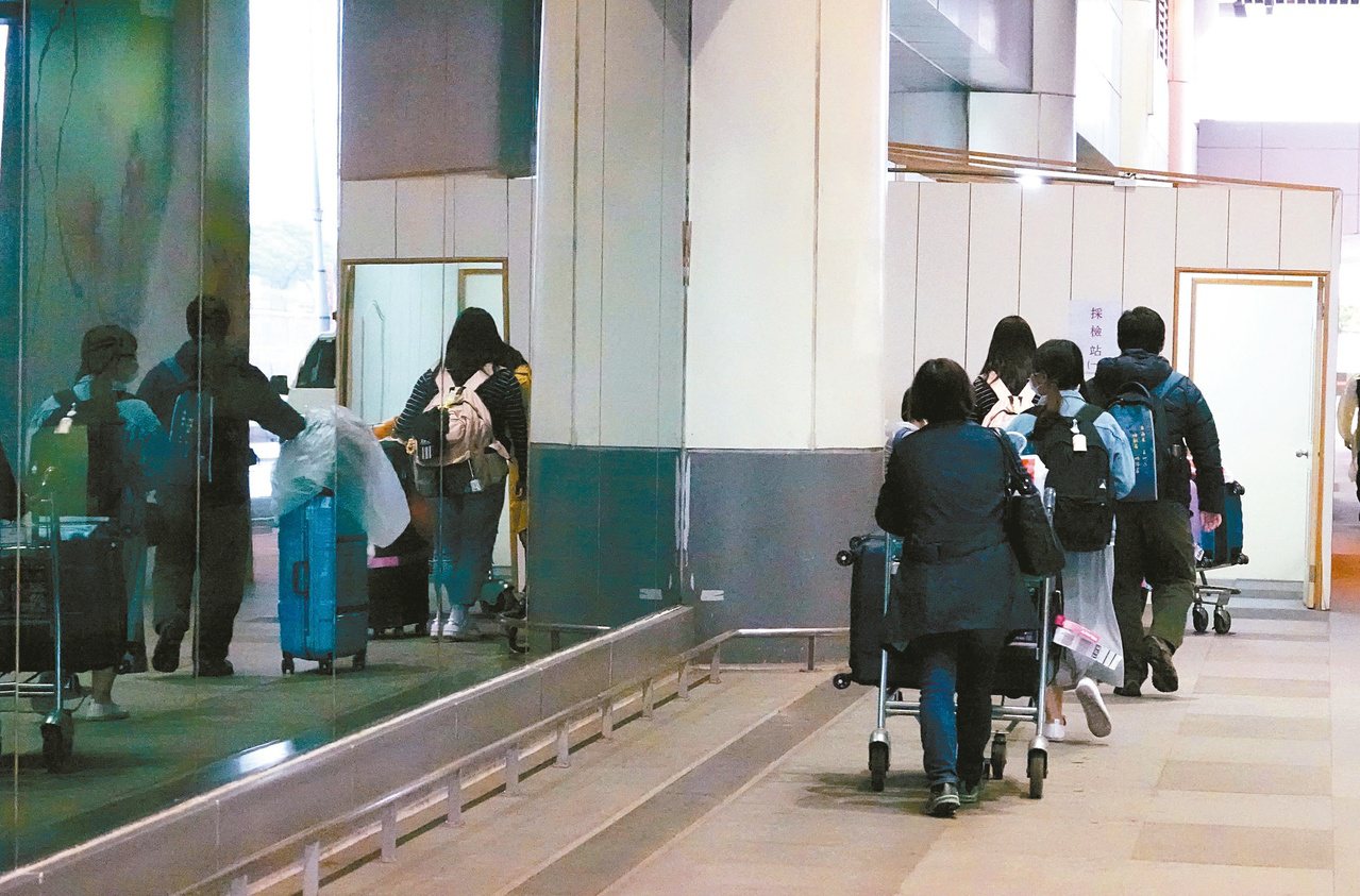 入境旅客有症狀者必須集中檢疫，等待採檢結果。不少旅客在採撿站前排隊等候。本報資料照片
