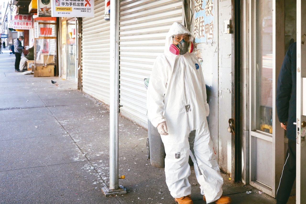 紐約疫情嚴重，在法拉盛華人社區，一位民眾身穿防護服去藥店取藥。