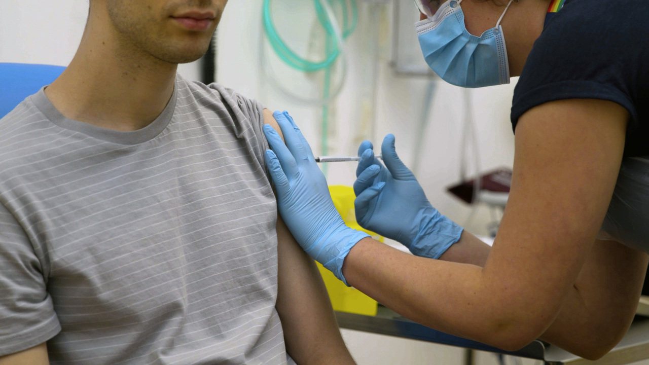 新冠疫苗研發需要做人體試驗，故意讓健康者感染可能致命的新冠病毒，引起有關道德問題的爭議。圖為醫師給志願者注射疫苗。美聯社