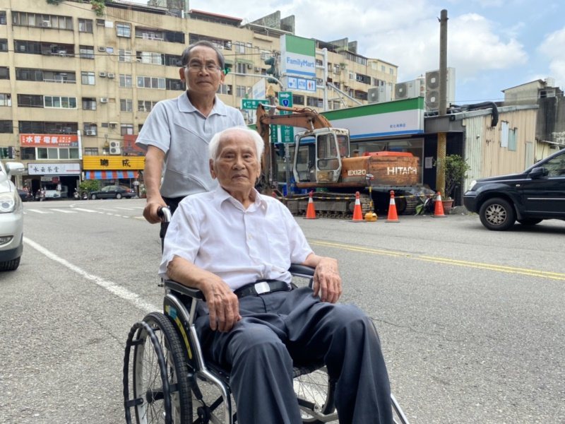 今年99歲的理髮老師傅沈駿魁，去年因行動不便，每天都由次子沈瑞昌推著外出散步。