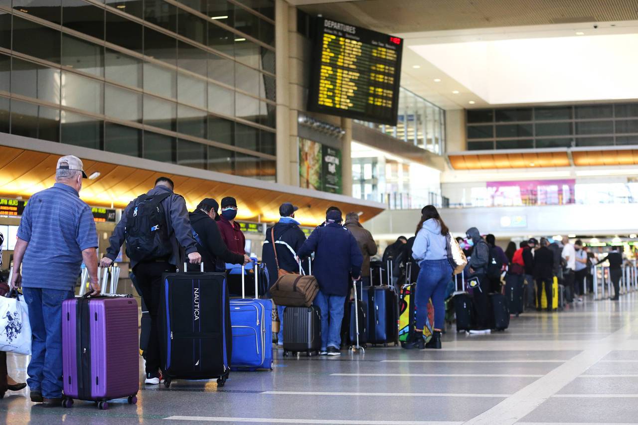美國洛杉磯疫情拉警報，近日衛生機關下令，南加州以外進入洛杉磯的旅客必須檢疫隔離10天。圖為22日洛杉磯機場內大排長龍等待報到的旅客。法新社