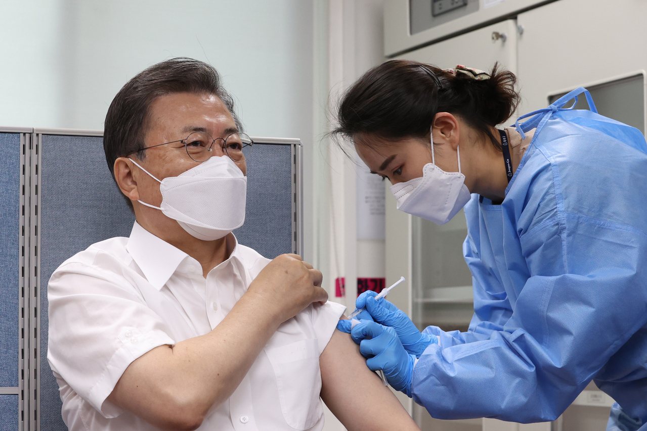 南韓總統文在寅（左）23日在首爾接種AZ疫苗。（歐新社）