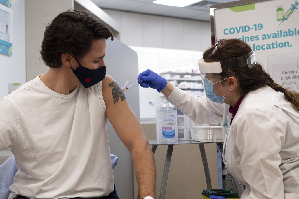 加拿大總理杜魯道(左)今天接種阿斯特捷利康藥廠的COVID-19疫苗第一劑。美聯社