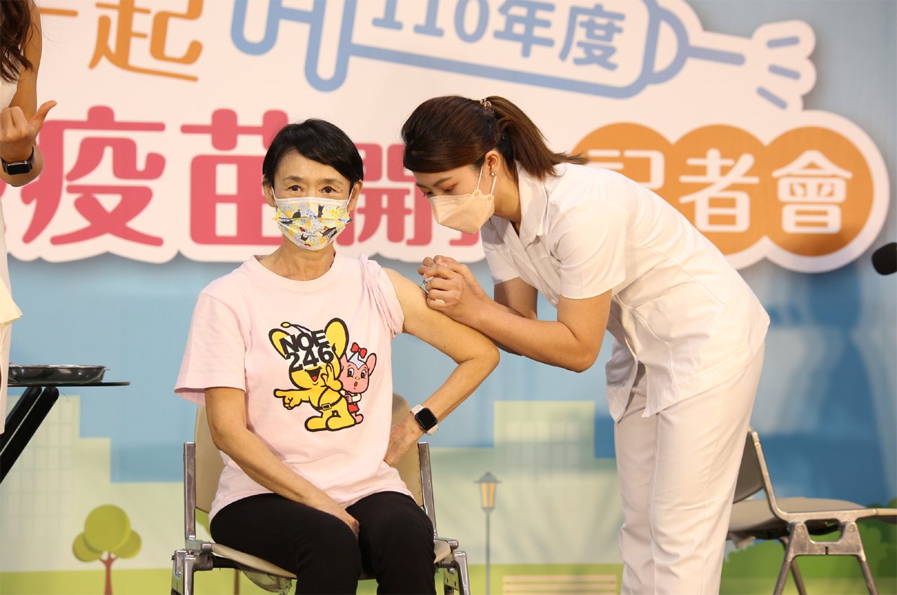 藝人譚艾珍（左）擔任衛福部疾管署的防疫大使，在記者會中挽袖施打流感疫苗。衛福部疾管署提供