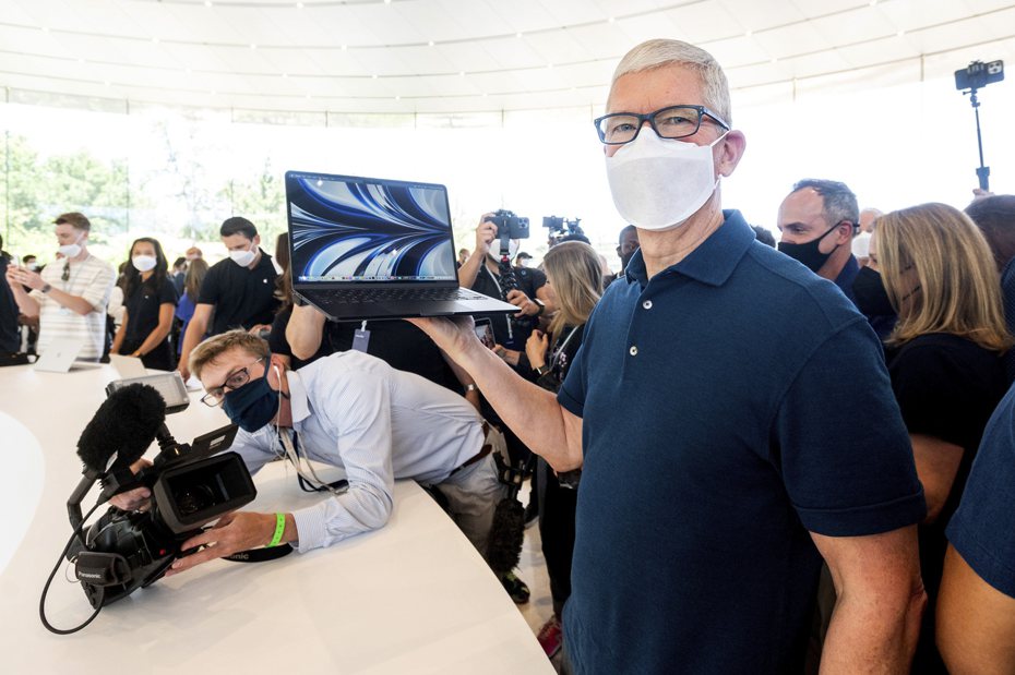 蘋果執行庫克6日在開發者大會上，手持搭載M2晶片的最新款MacBook Air。  美聯社