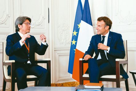 法國總統馬克宏（右）2022年7月11日在「選擇法國」活動上與輝能執行長楊思枏相談甚歡。（路透）