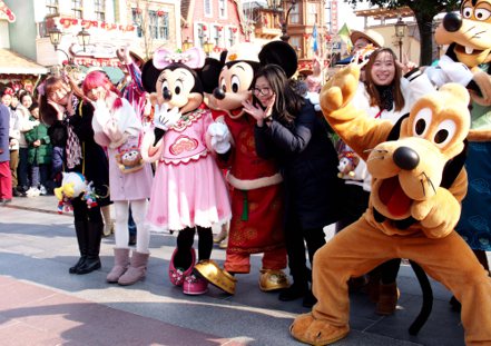 上海迪士尼主要動畫角色與遊客合影。新華社