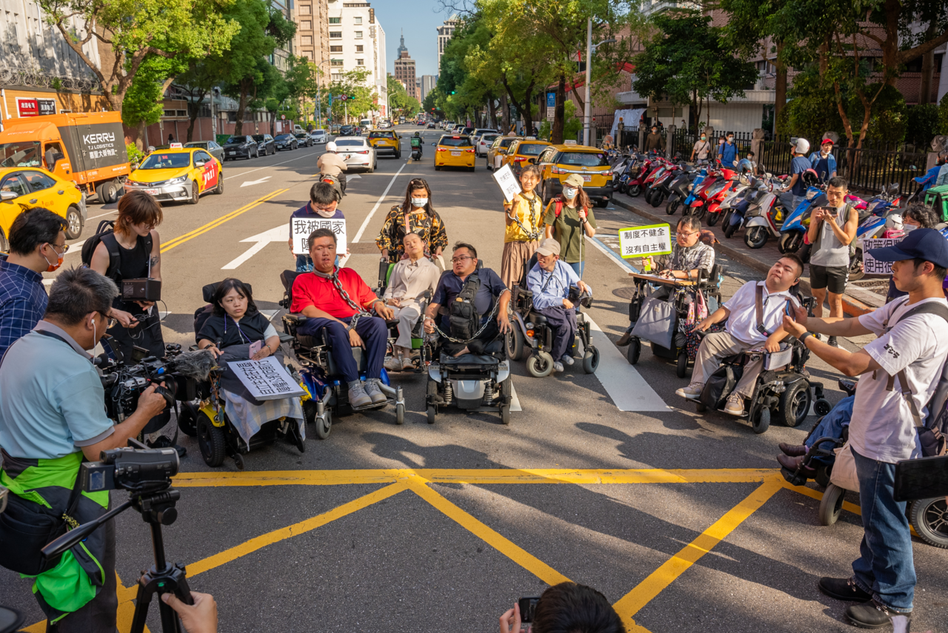 近二十名台灣障礙者黑紙革命聯盟成員突襲佔據濟南路一段車道，聯盟發起人林君潔表示：「我們已經『被障礙』很久了，只是要借個幾分鐘表達訴求。」 圖／蔡宗儒攝影