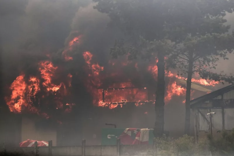 智利有關當局今天表示，中部地區的森林大火已奪走至少51條人命，且死傷數據可能會進一步攀升。圖為智利瓦爾帕萊索地區比納薩瑪的森林火災，工業區的一棟建築被大火燒毀。 圖／法新社