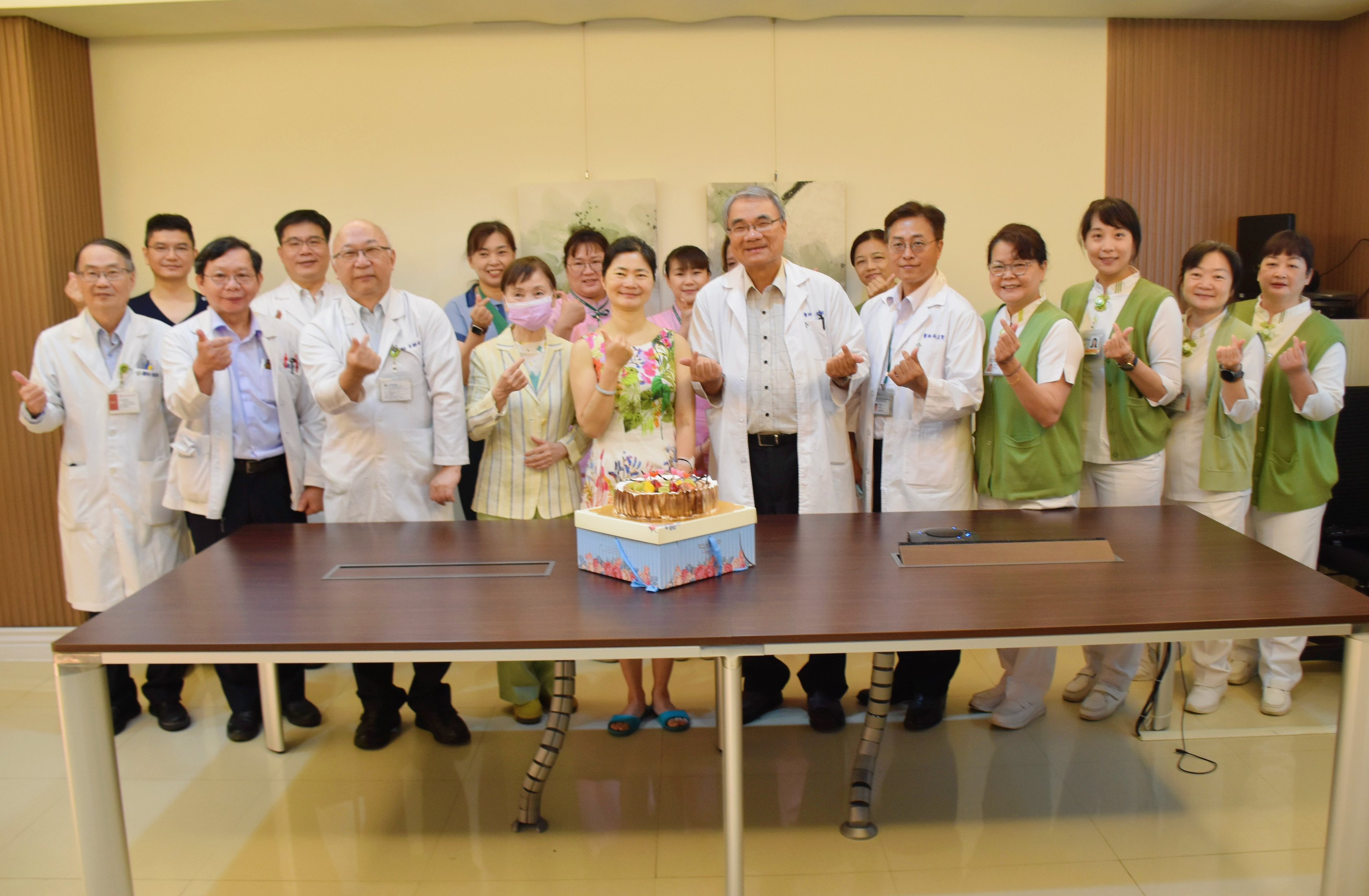 在台南市立醫院醫治的重症個案黃小姐（前），經過22天治療順利出院，成為寶林茶室食品中毒案第一位重症出院的患者。出院時，醫療團隊切蛋糕為她慶祝。 圖／台南市立醫院提供