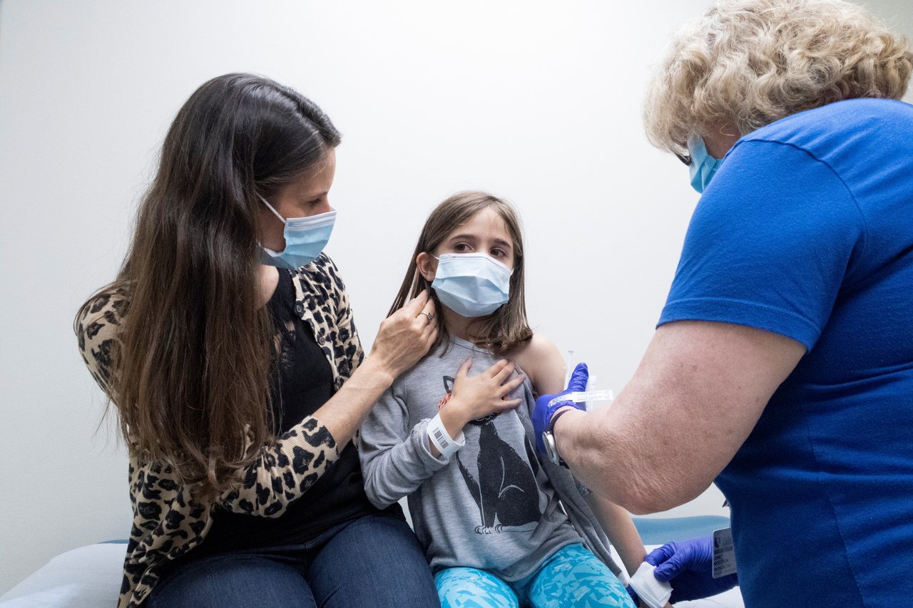 圖為北卡州一名女童在母親協助下，接種輝瑞疫苗。(路透)