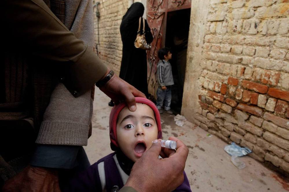 醫護人員與志工挨家挨戶為孩童接種口服疫苗。 （圖／美聯社）