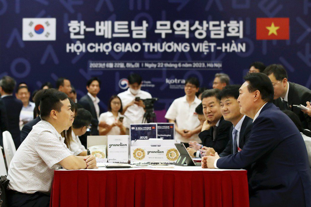 2023年6月22日，韓國總統尹錫悅（右）在越南河內會議中心舉行的韓越夥伴關係博覽會上與商人進行貿易磋商。 圖／歐新社