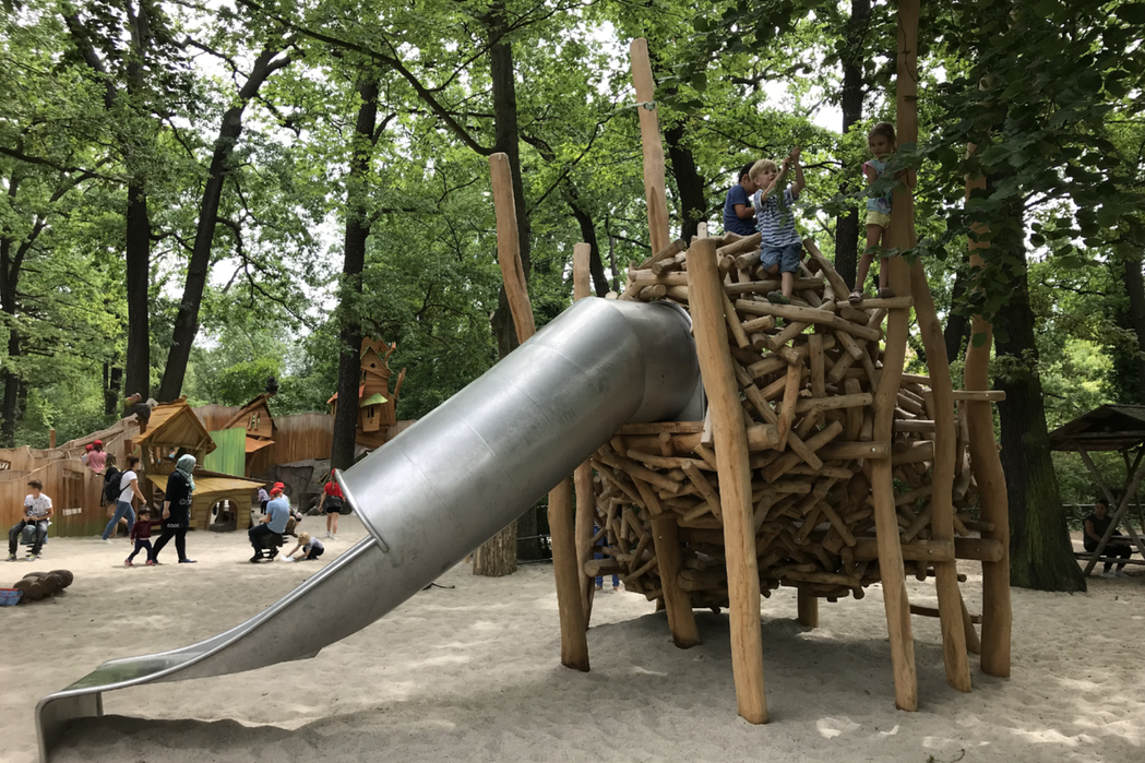德國柏林動物園的幼兒遊戲場，滑梯入口設計模仿鳥巢，三、四個幼兒爬到滑梯頂端，玩起樹木垂下的枝葉。 圖／作者提供