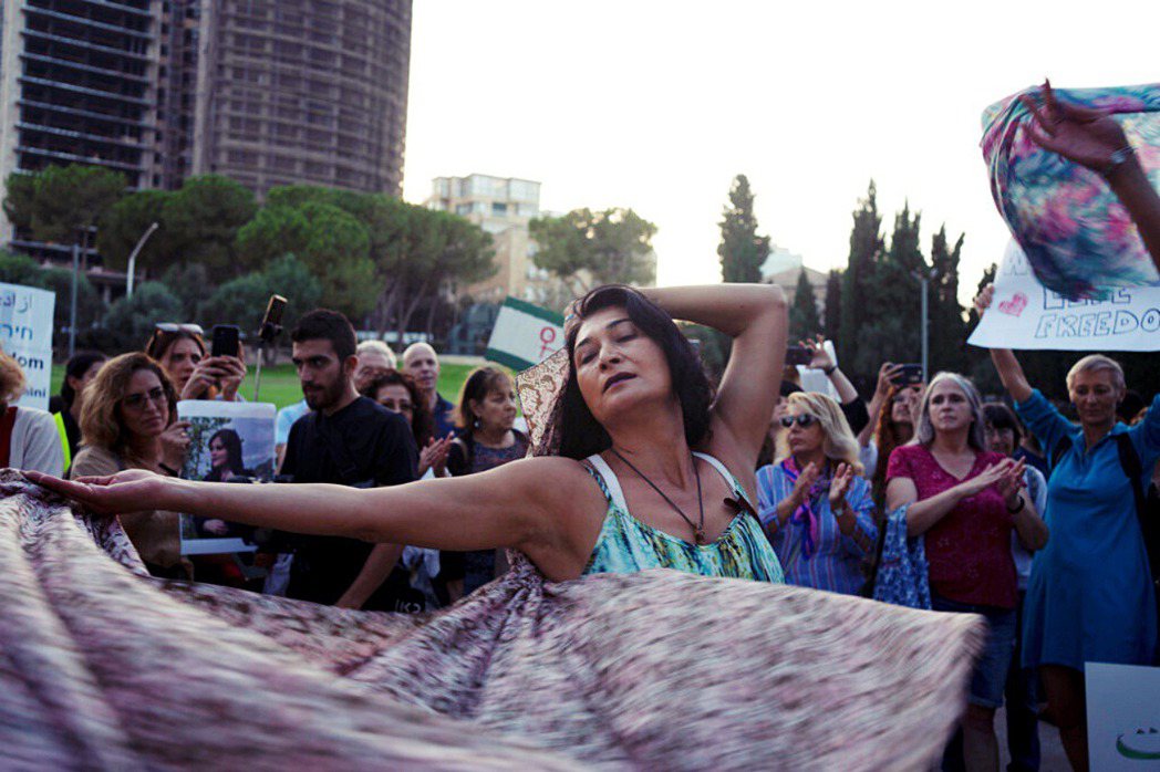 圖為2022年10月，一名婦女在耶路撒冷的一場示威行動舉著圍巾跳舞，抗議伊朗阿米...