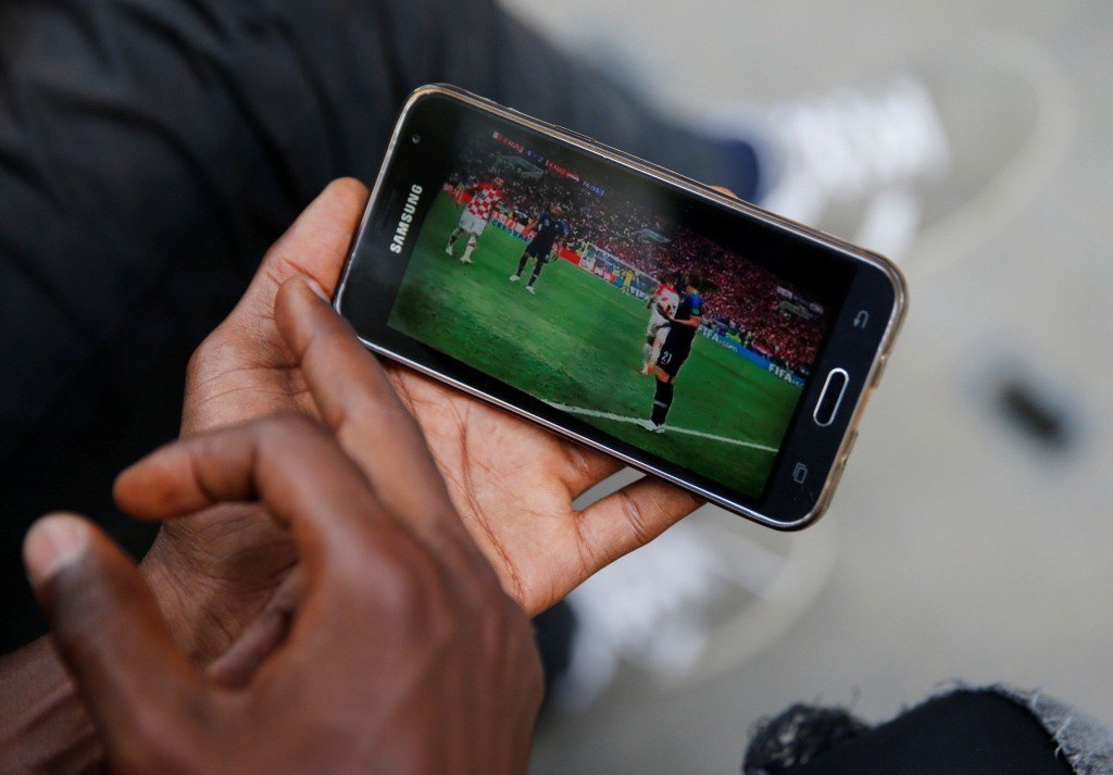 一名球迷以手機收看世界盃。 圖／路透社