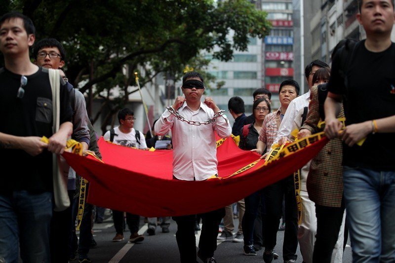 2017年，台灣公民李明哲被中國控以「顛覆國家政權罪」而遭逮捕，迄今仍身陷中國黑牢。圖為2018年3月，台灣民眾發起的聲援遊行。 圖／歐新社