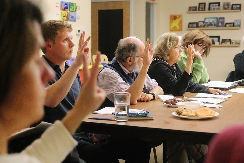 圖為美國密西根州的Newberry Place合作住宅住戶們，在參與決策會議時舉手表決。 圖／美聯社