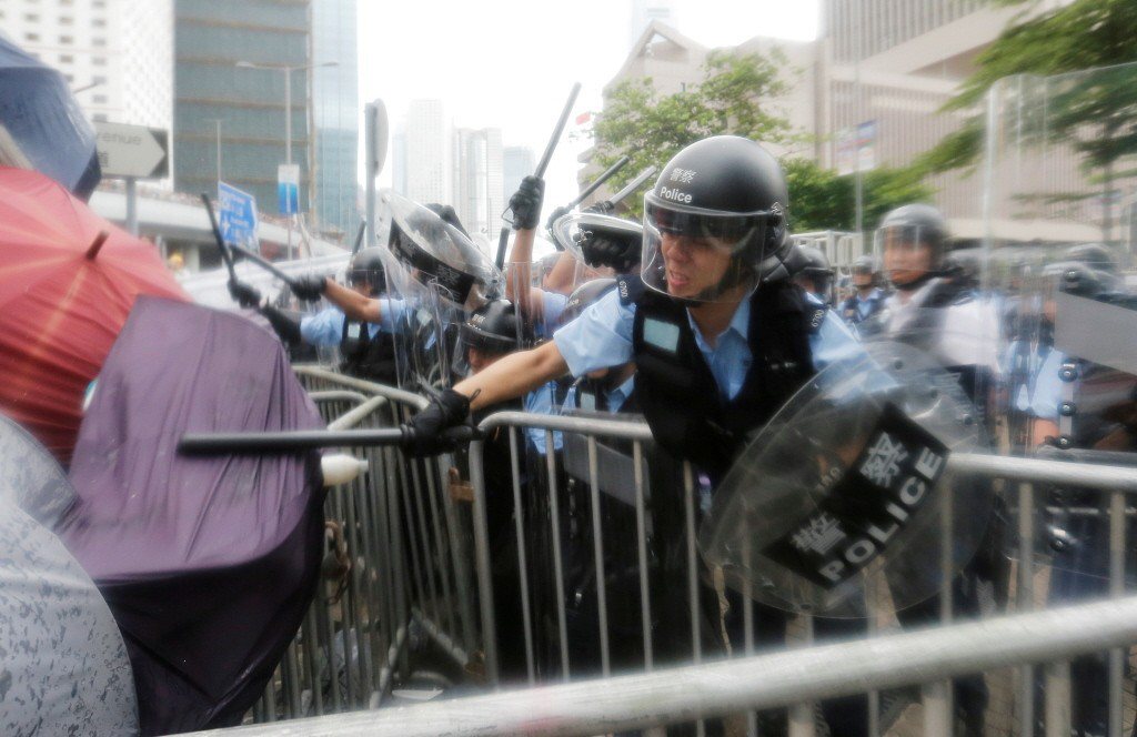 香港反送中遊行期間，港警持警棍武力驅離示威者。 圖／路透社