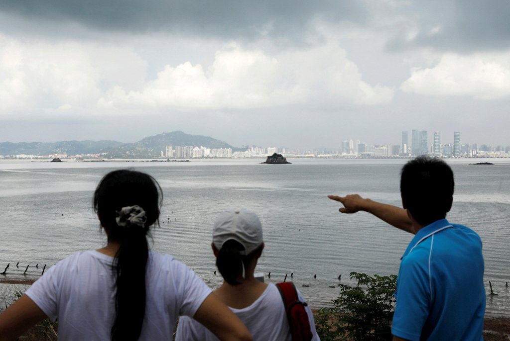 一名遊客在金門烈嶼指向中國廈門。 圖／路透社