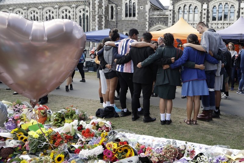 學生為屠殺事件身亡的死者祈福禱告。 圖／美聯社